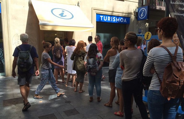 Turistas ante la oficina de Turismo